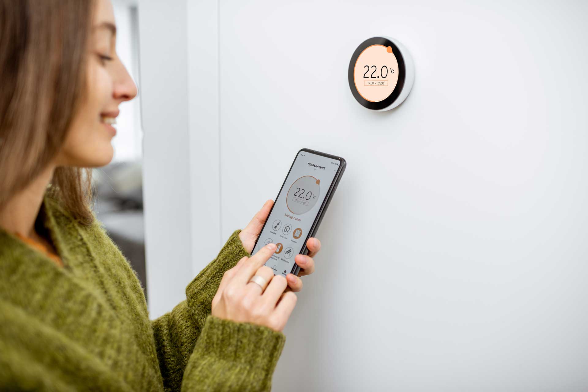 woman using a smart thermostat